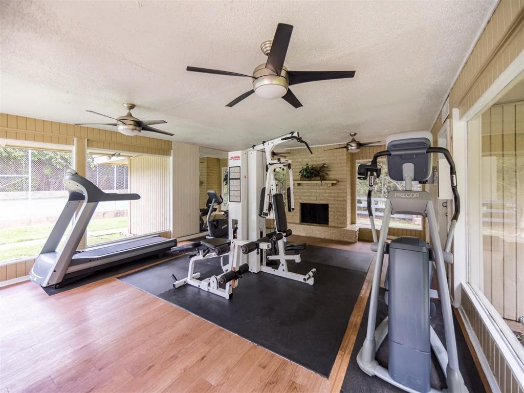 the gym in the home has a ceiling fan and exercise equipment