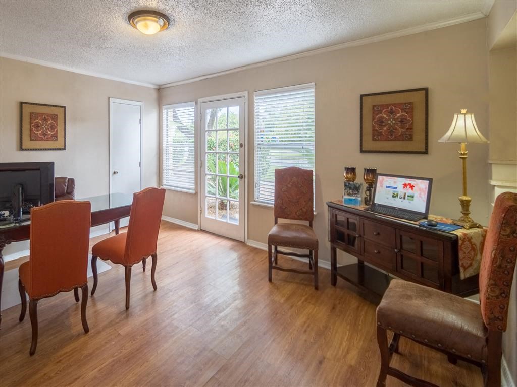 a living room and dining room with a table and chairs