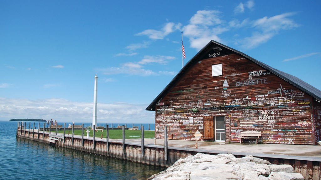 an old building on the dock of a pier with the water