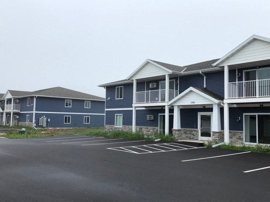 a row of blue houses with balconies and a parking lot