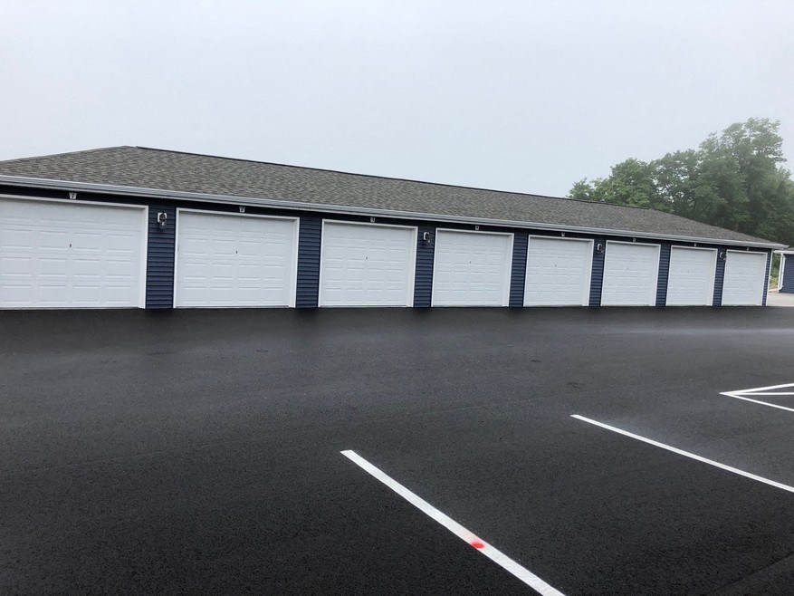 a row of white garage doors in a parking lot