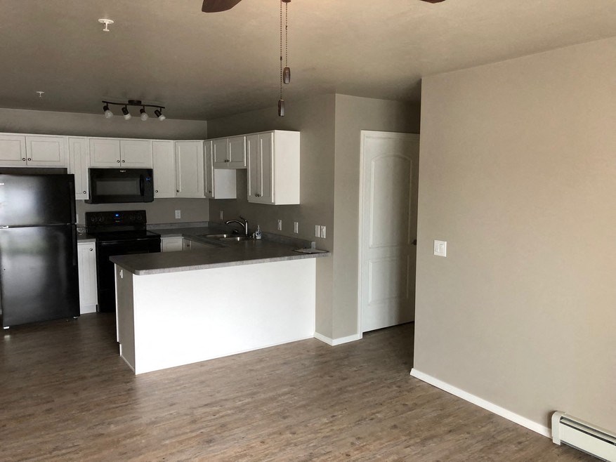 an empty kitchen with white cabinets and a counter top