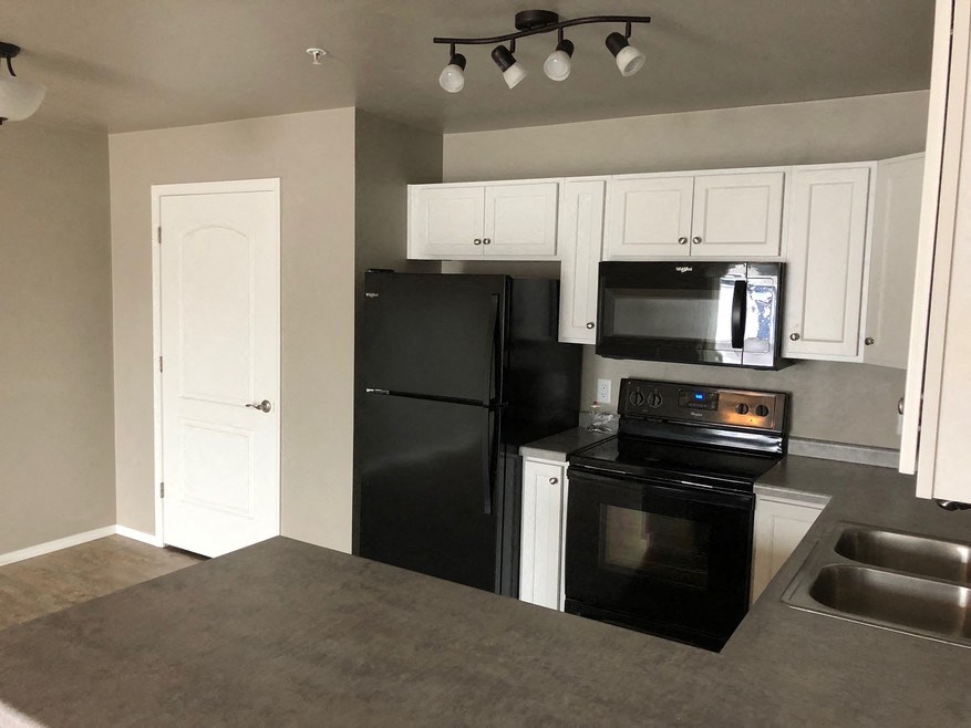 a kitchen with black appliances and white cabinets