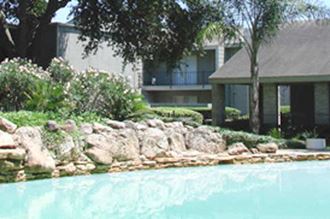 a large pool with a house in the background