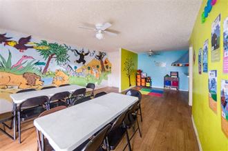 a room with a table and chairs and a mural on the wall
