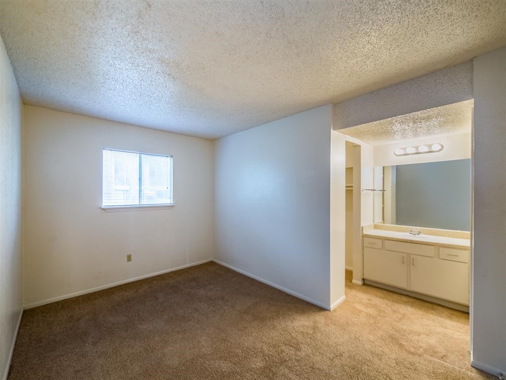 an empty living room with a sink and a mirror