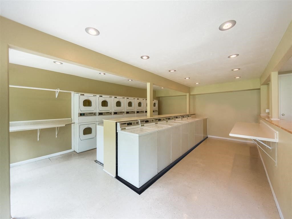 a large laundry room with washers and dryers and a sink