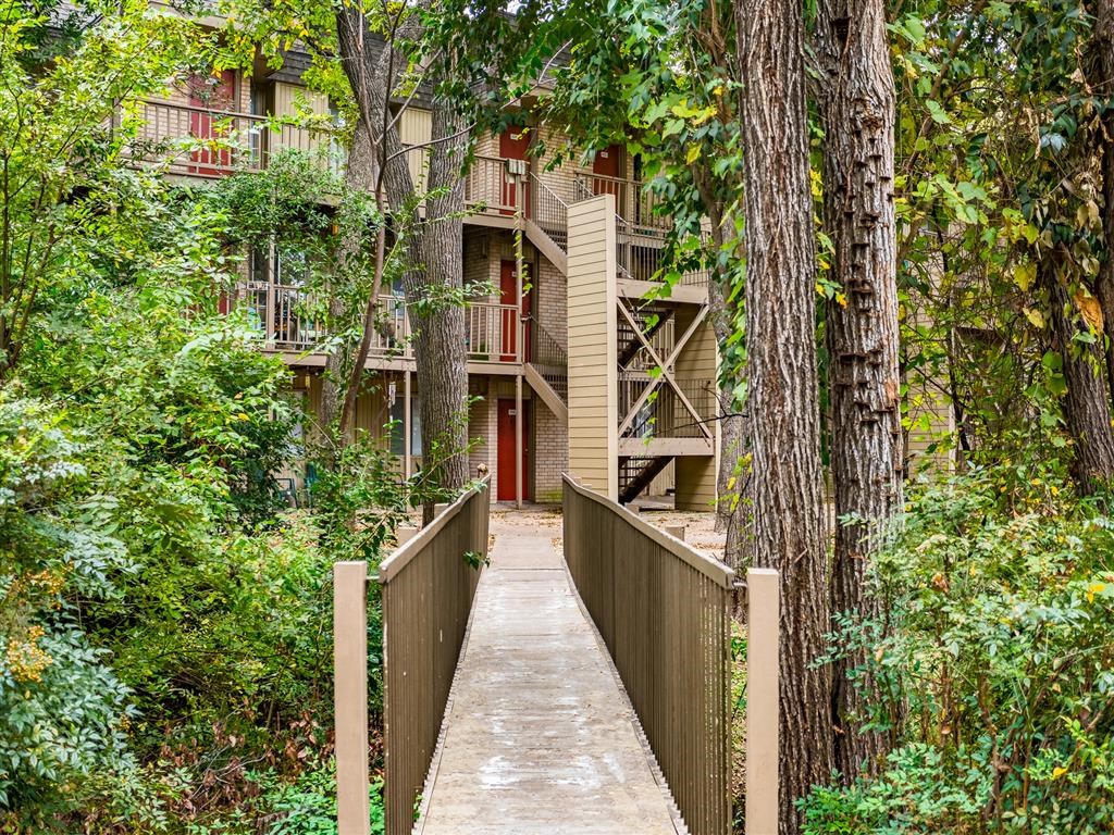 a bridge leading to an apartment building in the woods