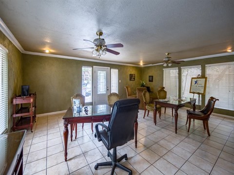 a living room with a ceiling fan and a table and chairs