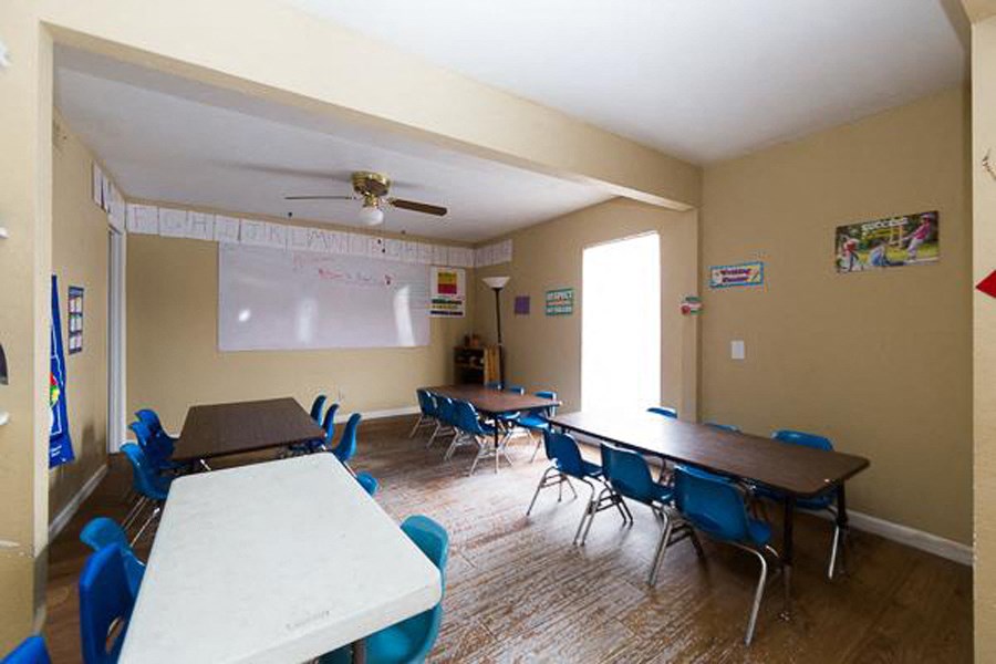 a classroom with tables and chairs and a whiteboard