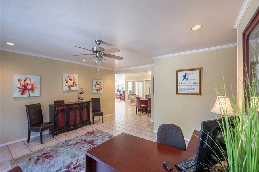 a living room with a table and a ceiling fan