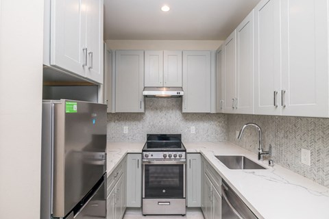 a kitchen with white cabinets and stainless steel appliances