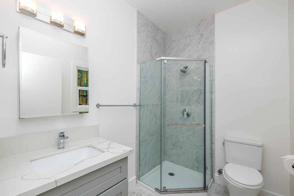 a white bathroom with a shower sink and toilet