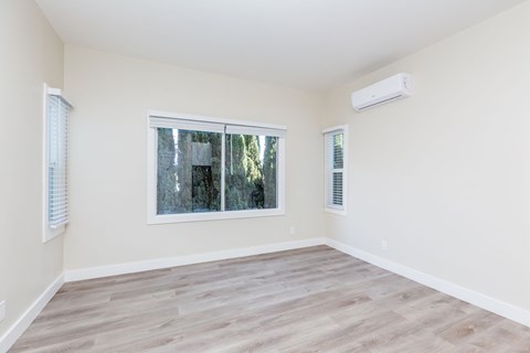 A room with a window and a wall-mounted air conditioner.