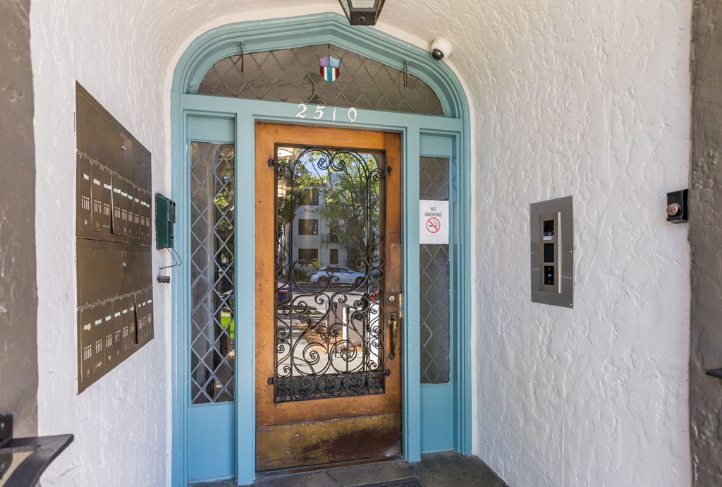 the front door of a restaurant with a wrought iron door knob and blue doors