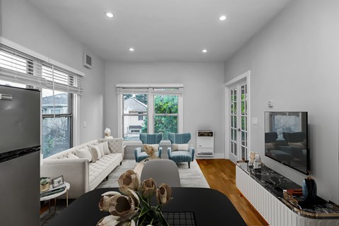 A modern living room with a television, sofas, and a dining table.