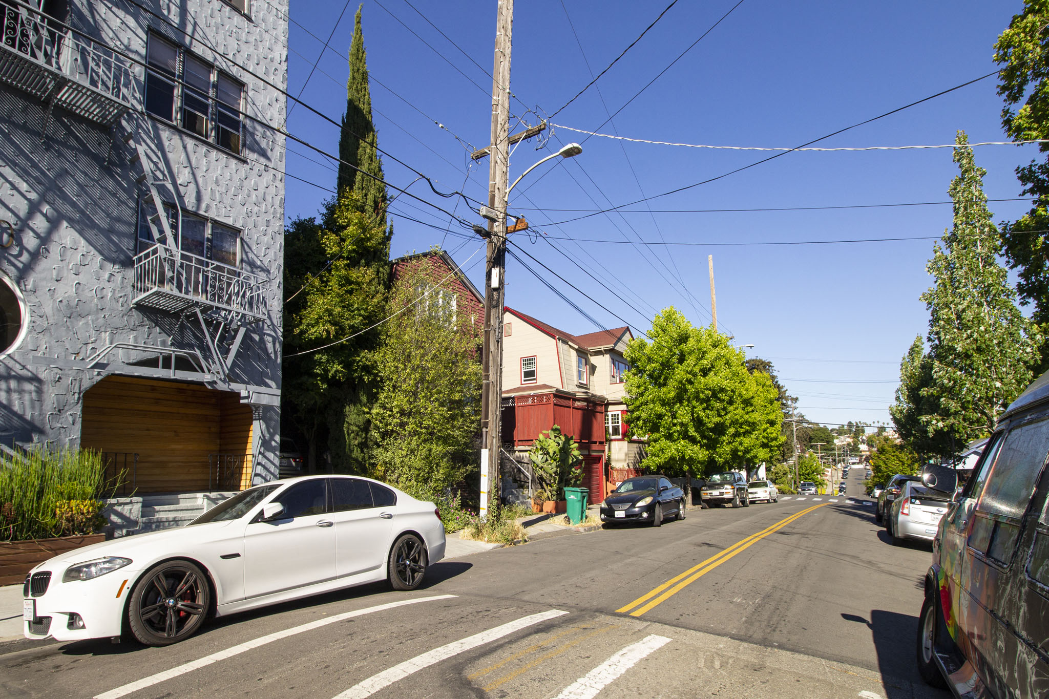 A white car is parked on the side of a street.