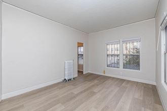 an empty living room with a radiator and a window