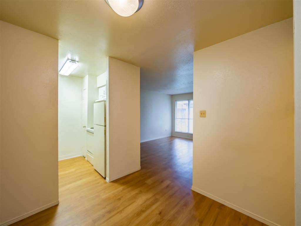 an empty living room with white walls and wood floors