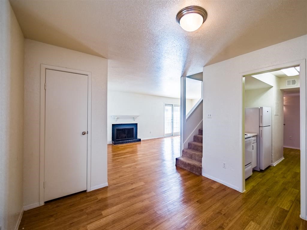 an empty living room with a staircase and a fireplace
