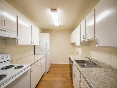 a kitchen with white appliances and granite counter tops