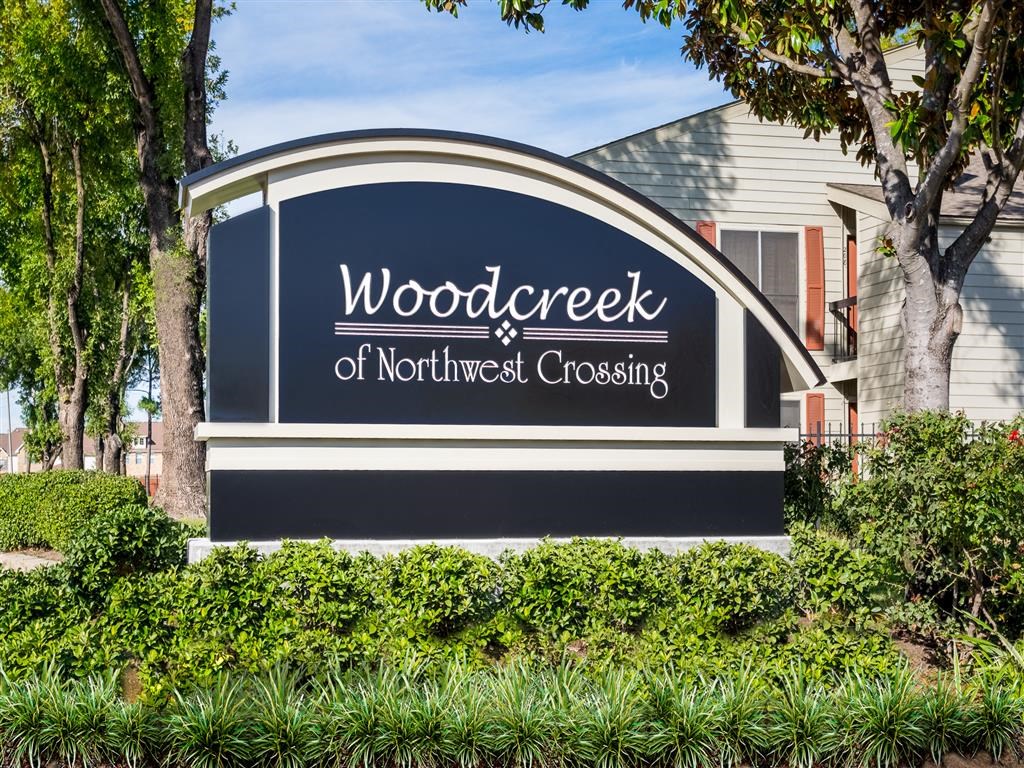 a sign for wooddeck of northwest crossing in front of a house