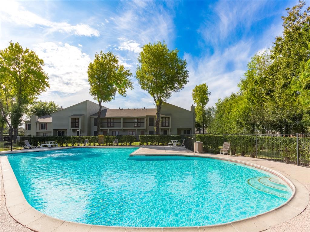 a large swimming pool with a building in the background