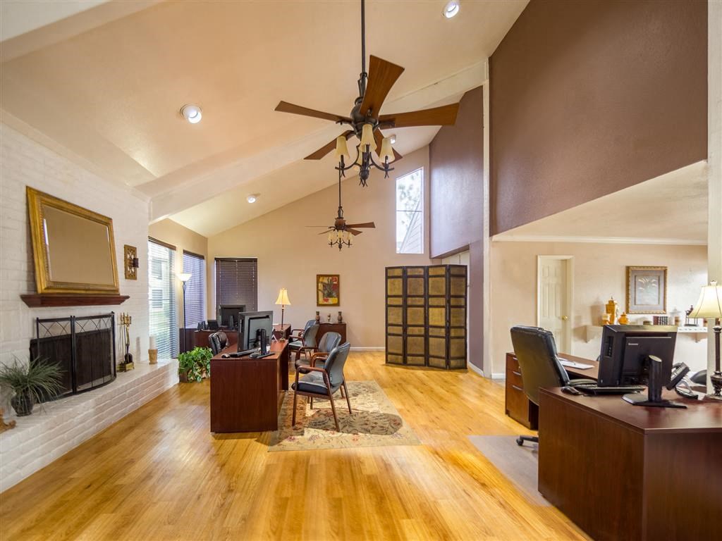 a living room with a ceiling fan and a fireplace