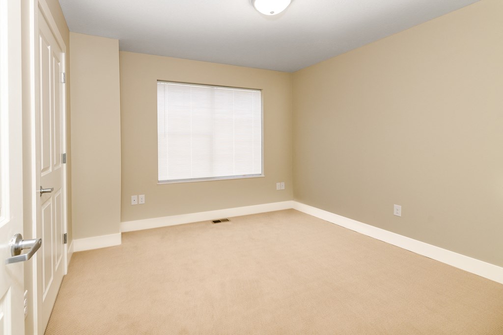 an empty room with a window and a door