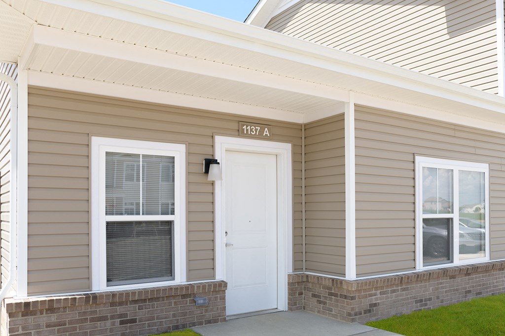 the front of a house with a white door and a porch