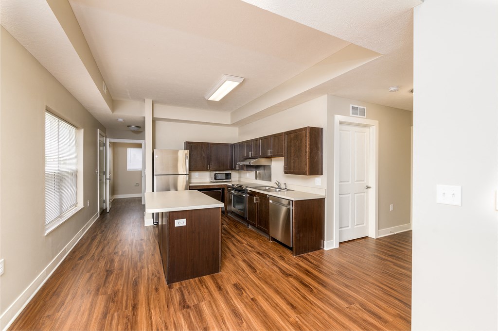 a kitchen with wood flooring and stainless steel appliances and