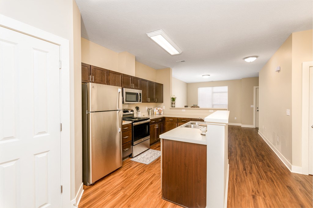 a renovated kitchen with stainless steel appliances and wood flooring