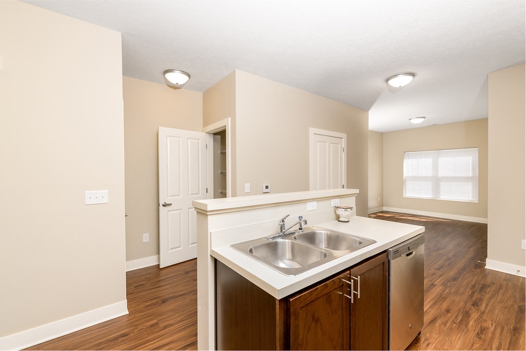 an empty kitchen and living room with a sink and a window