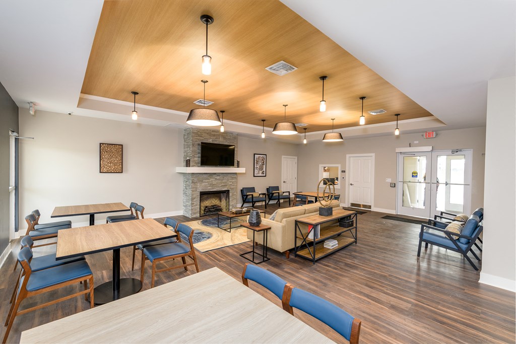 a large living room with tables and chairs and a fireplace