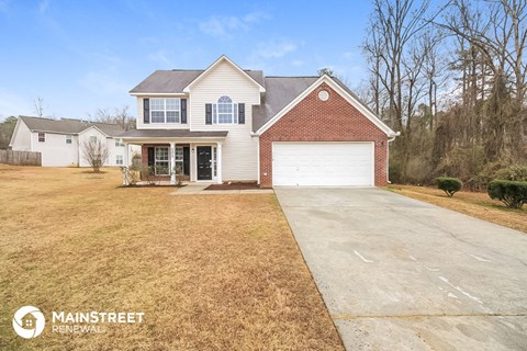 a home with a large driveway and a white garage door