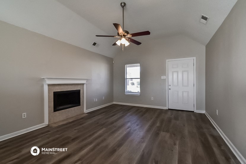 the living room with fireplace and ceiling fan