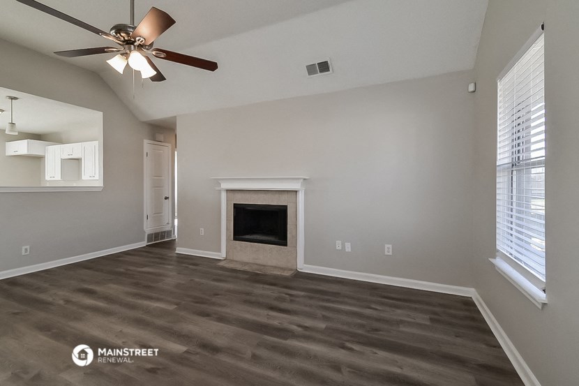 the living room with fireplace and ceiling fan