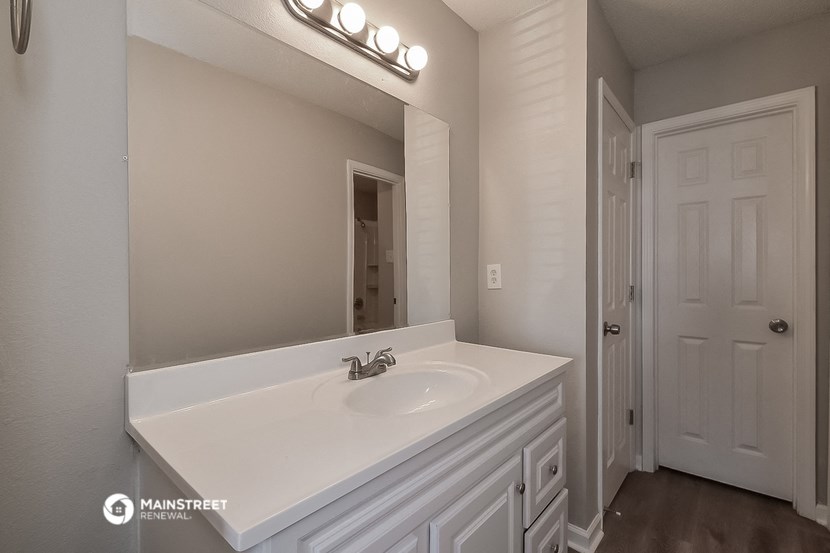 a bathroom with a white sink and a mirror
