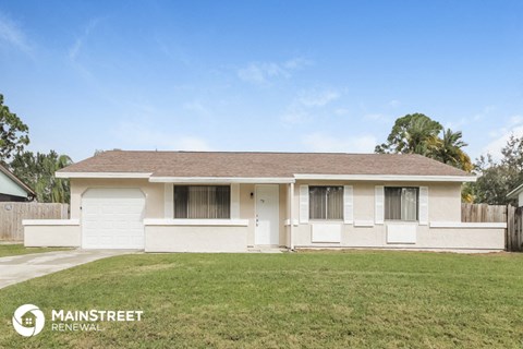 front view of a white house with a yard and grass