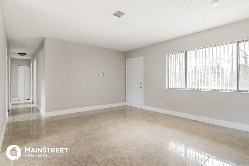 a spacious living room with tile flooring and a large window