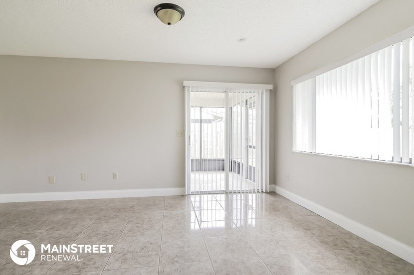 an empty living room with a door to a balcony