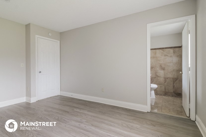 an empty room with a bathroom and a door to a toilet