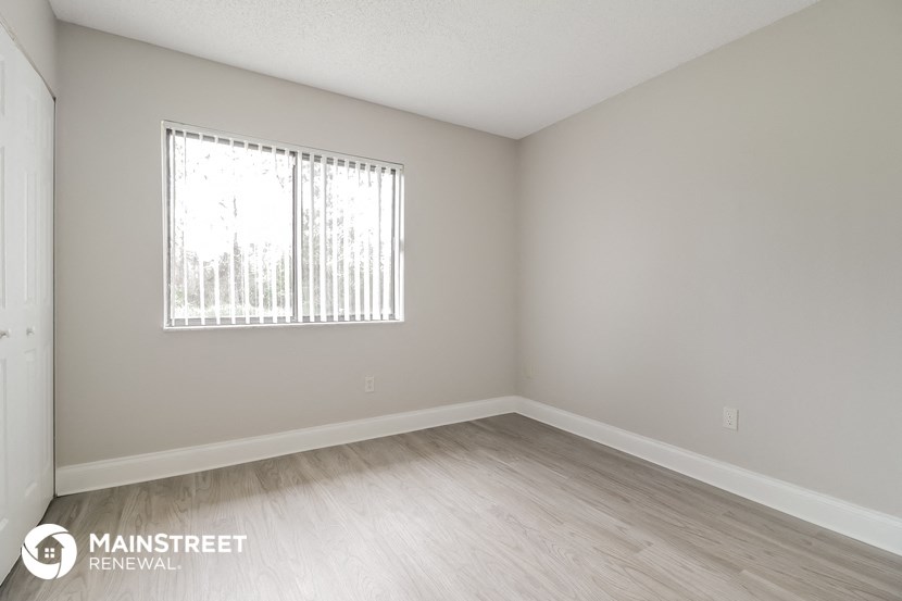 the upstairs bedroom with wood flooring and a window