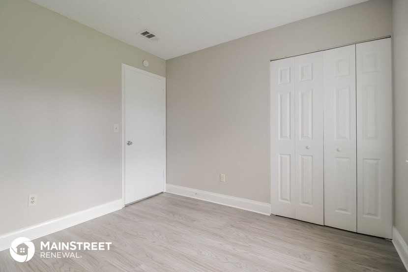 a bedroom with two white closets and a wood floor