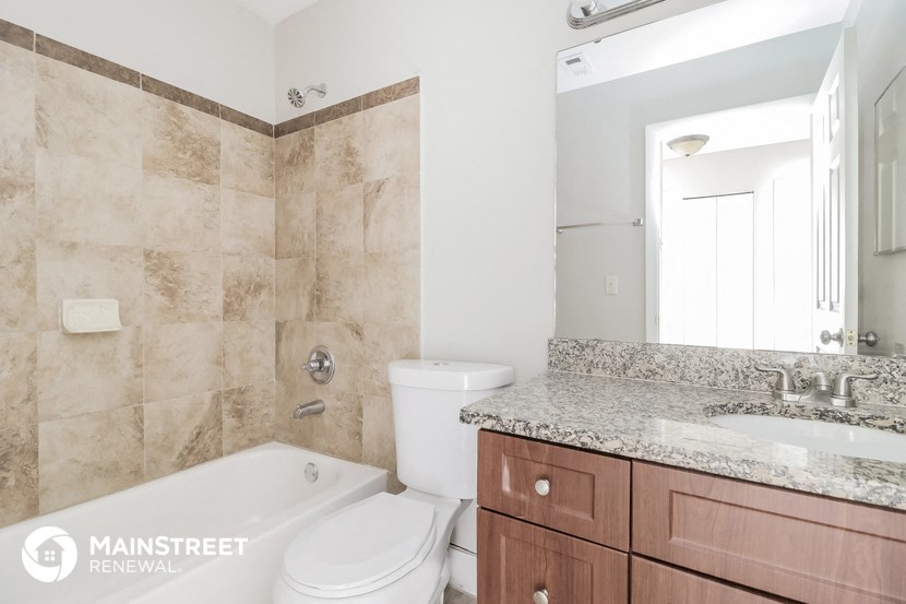 a bathroom with a tub toilet and sink and a mirror