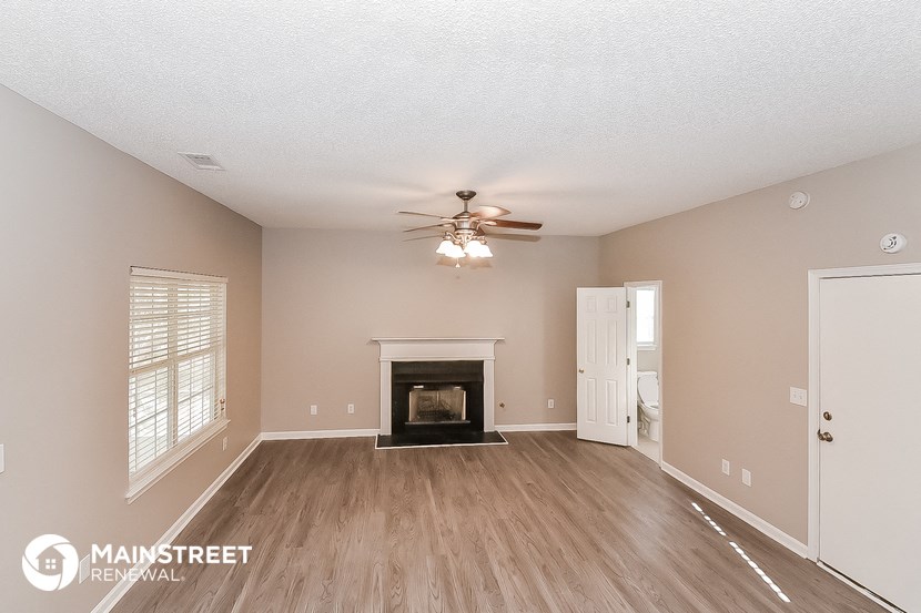 the living room with fireplace and ceiling fan