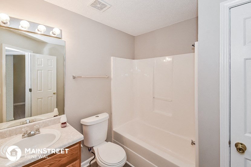 a bathroom with a shower toilet and sink and a mirror