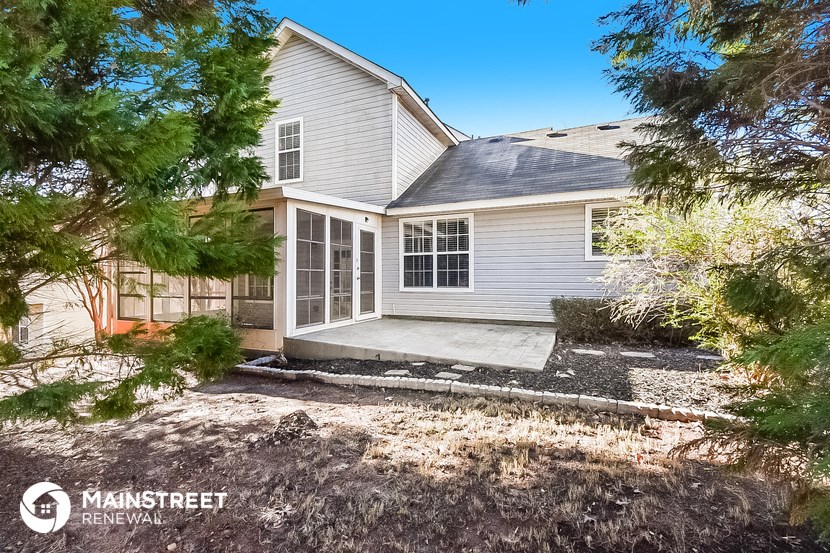 a white house with a porch and a driveway