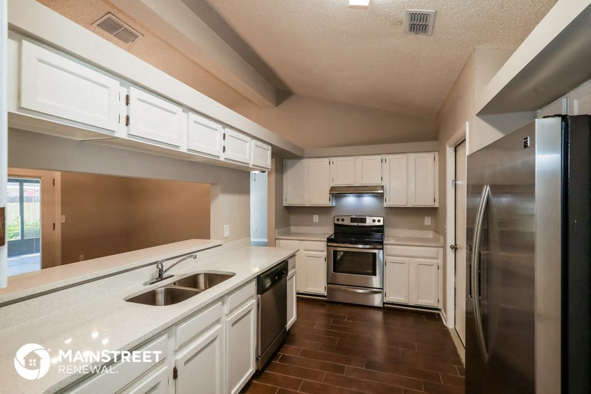 a kitchen with white cabinets and stainless steel appliances