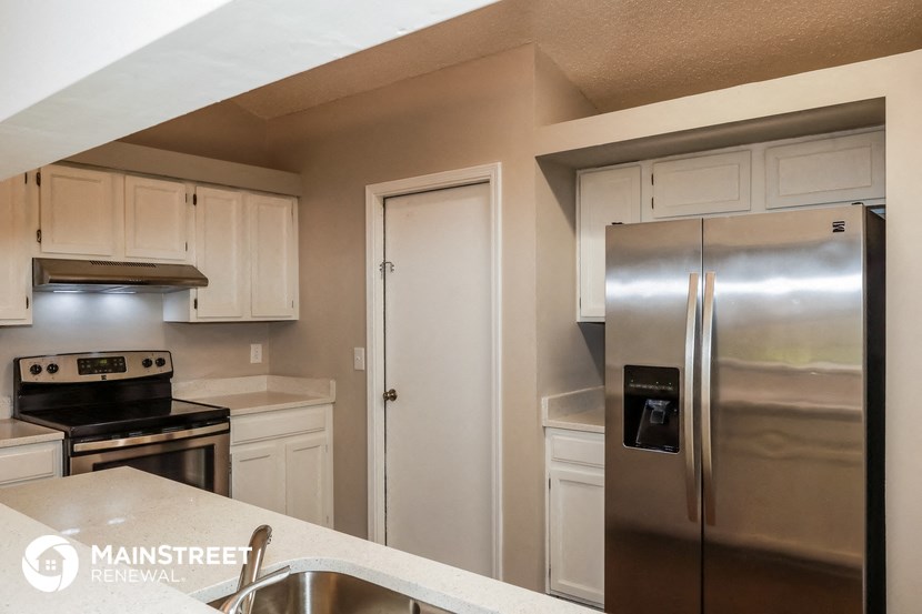 a kitchen with stainless steel appliances and white cabinets